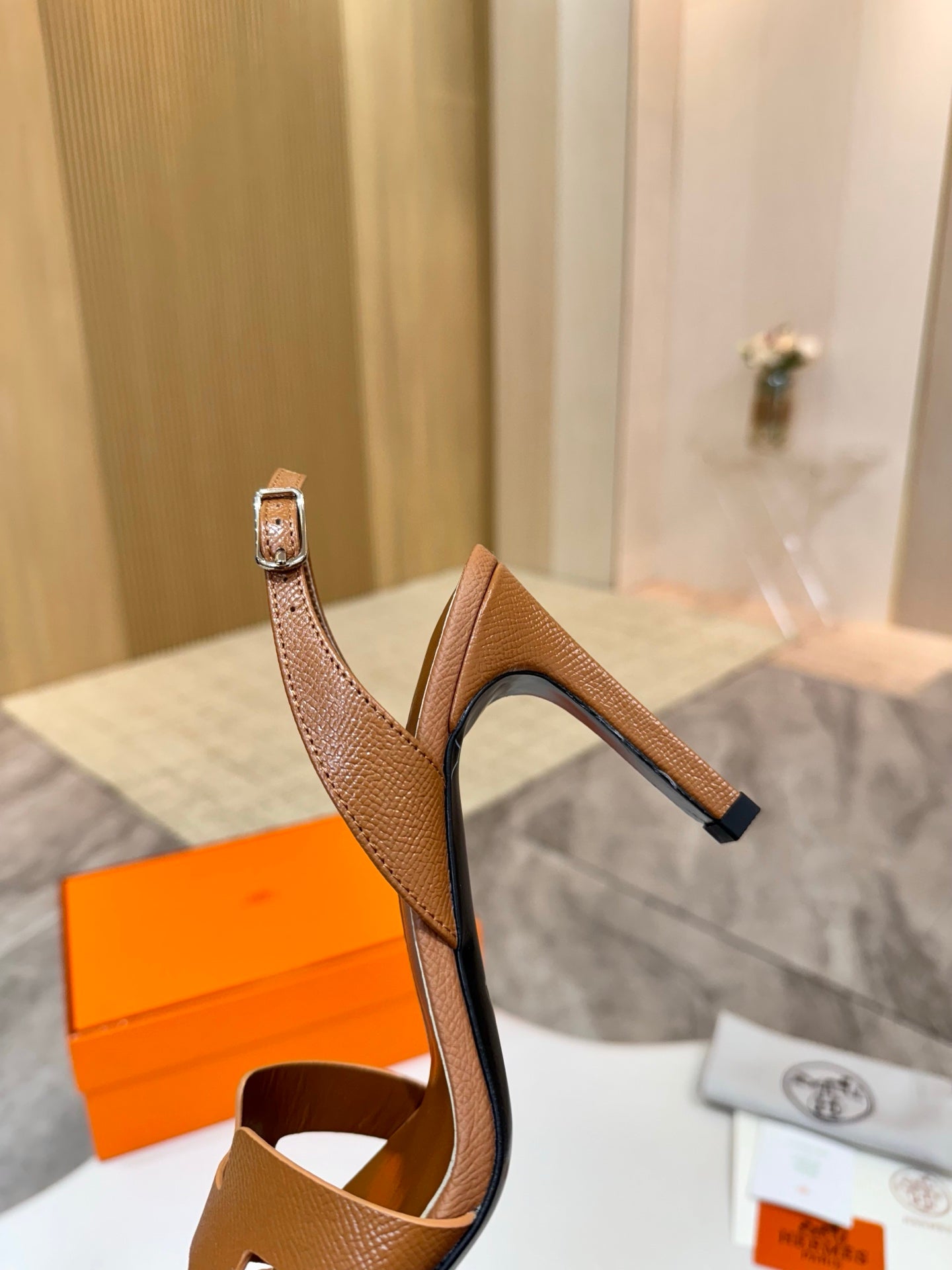 Brown leather heeled sandals from side view with ankle strap and open foot strap