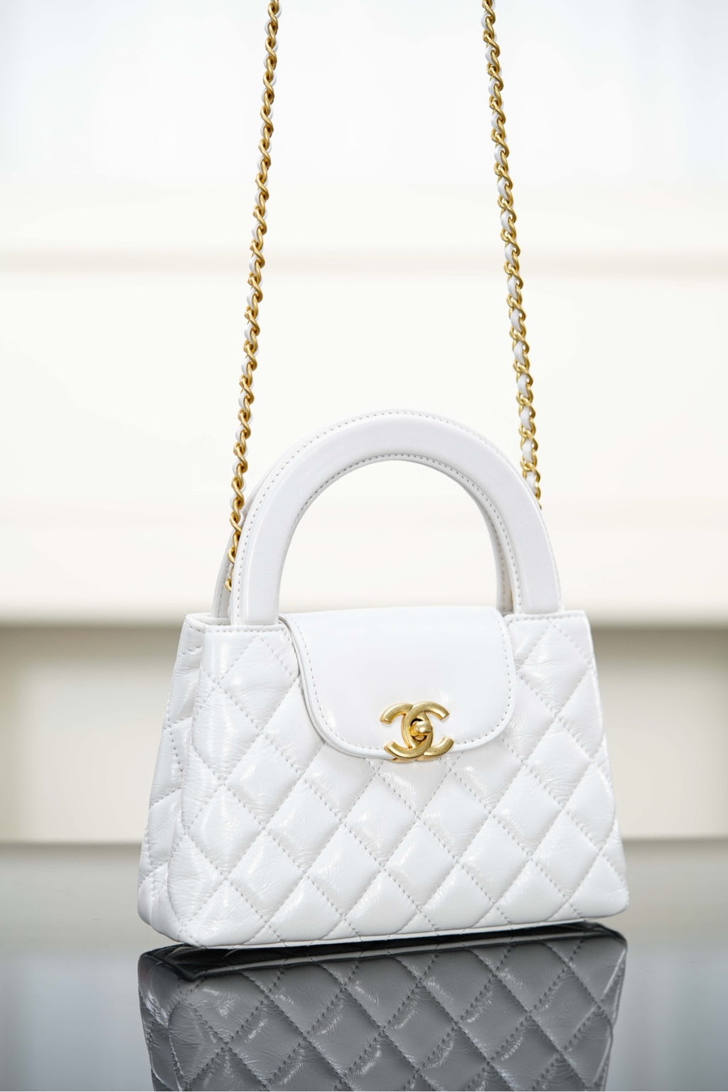 Chanel quilted handbag with gold chain strap and front logo clasp