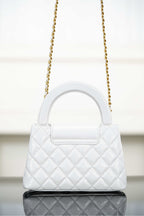 Chanel quilted handbag with top handle and gold chain strap