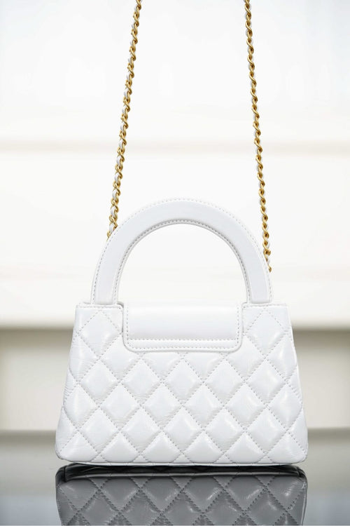 Chanel quilted handbag with top handle and gold chain strap
