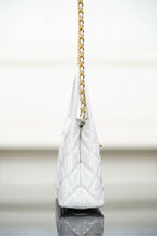 Chanel quilted handbag on a gold chain strap, angled side view
