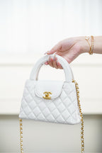 Chanel quilted handbag in white with top handle and gold chain strap
