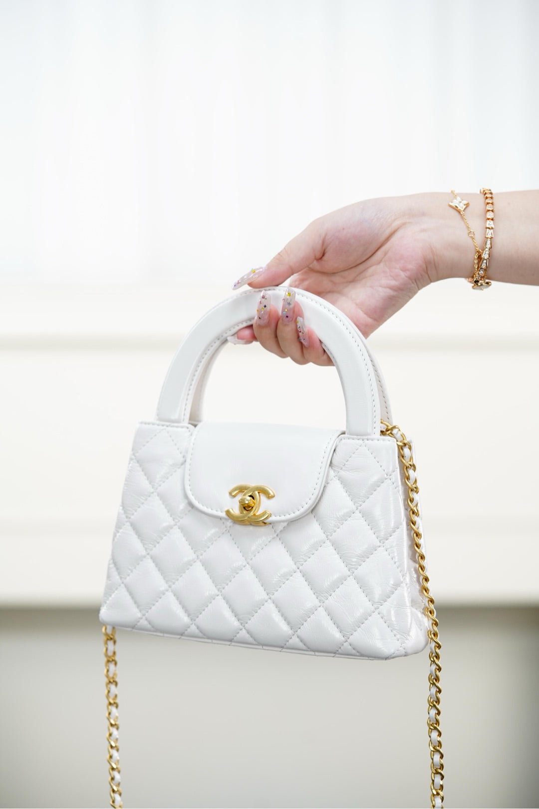 Chanel quilted handbag in white with top handle and gold chain strap