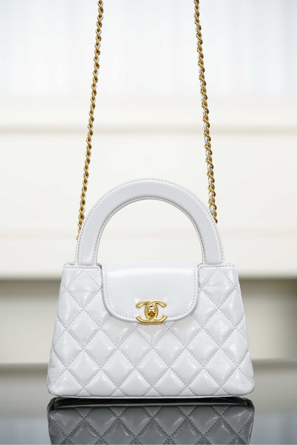 Chanel quilted handbag with top handle, gold chain strap and flap closure