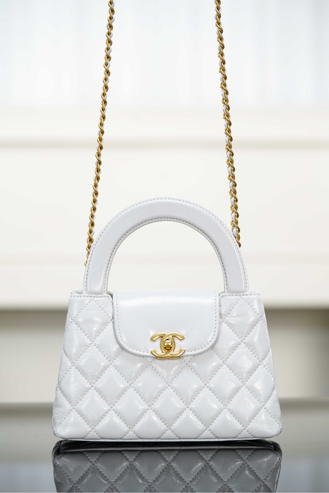 Chanel quilted handbag with top handle, gold chain strap and flap closure