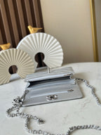 Silver Chanel mini shoulder bag with chain strap and front turn-lock clasp, side view
