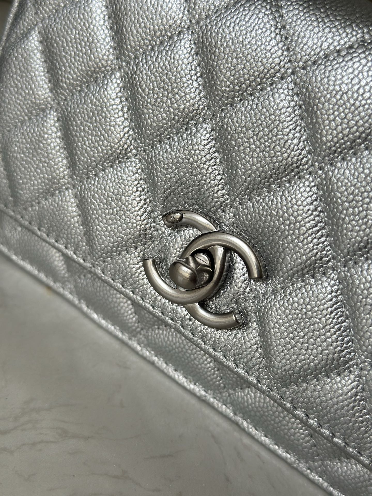 Silver Chanel CC logo clasp on quilted bag flap