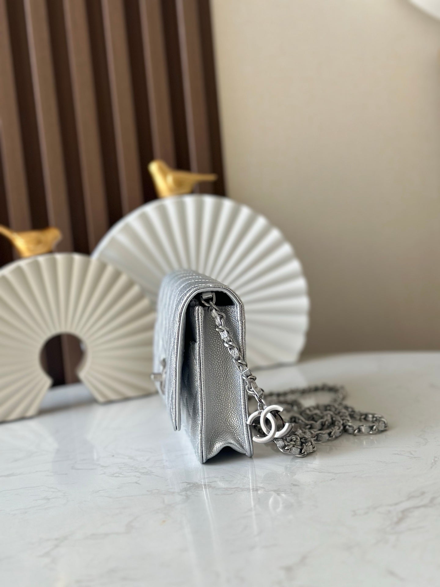 Silver Chanel mini bag with quilted sides and chain strap, front flap partially visible