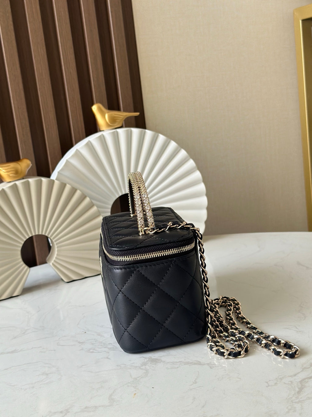 Quilted black mini crossbody bag with gold chain strap and zipper closure