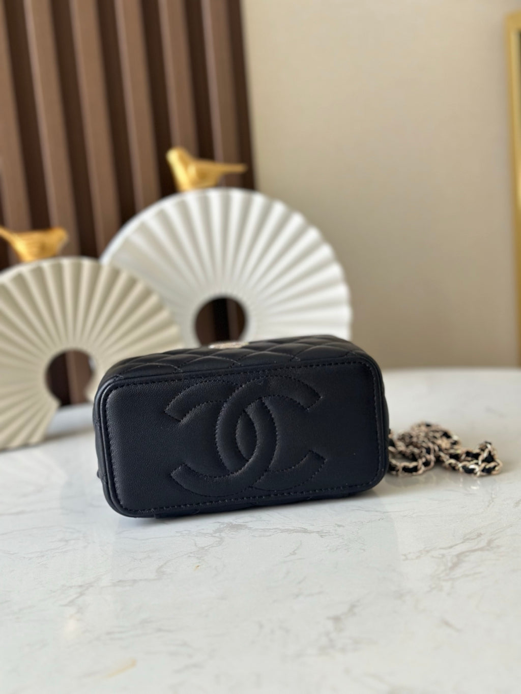 Quilted black mini bag with embossed CC logo on back and gold-tone hardware