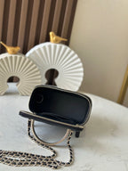 Black zip pouch bag with gold zipper, quilted base, and gold chain strap