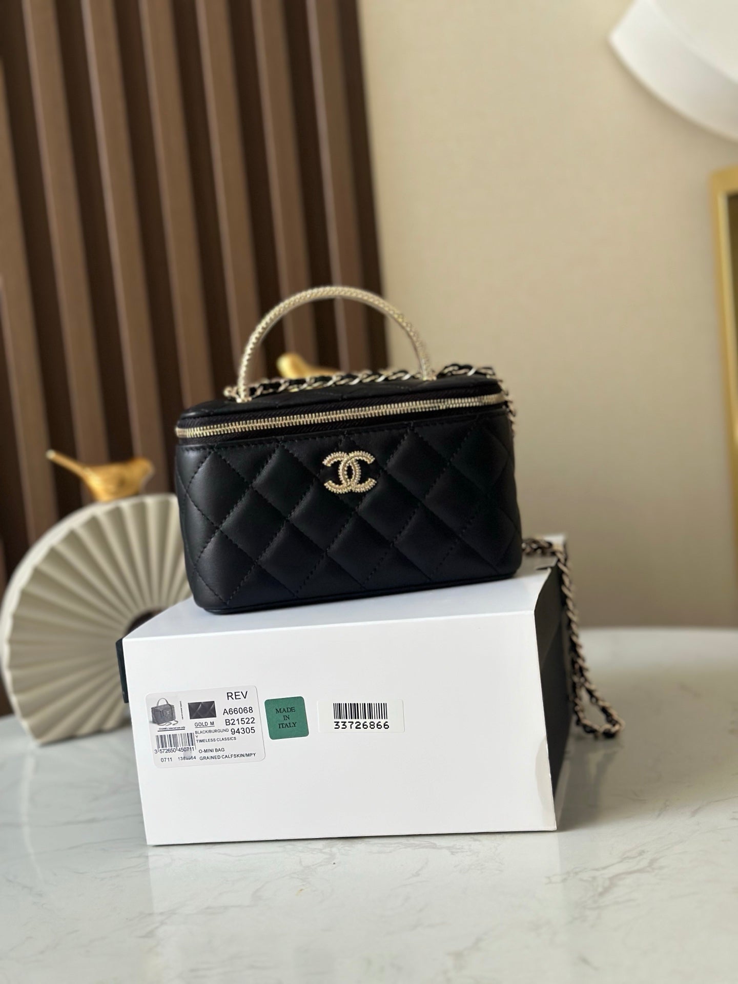 Quilted black mini bag with top handle, gold chain strap, CC logo front