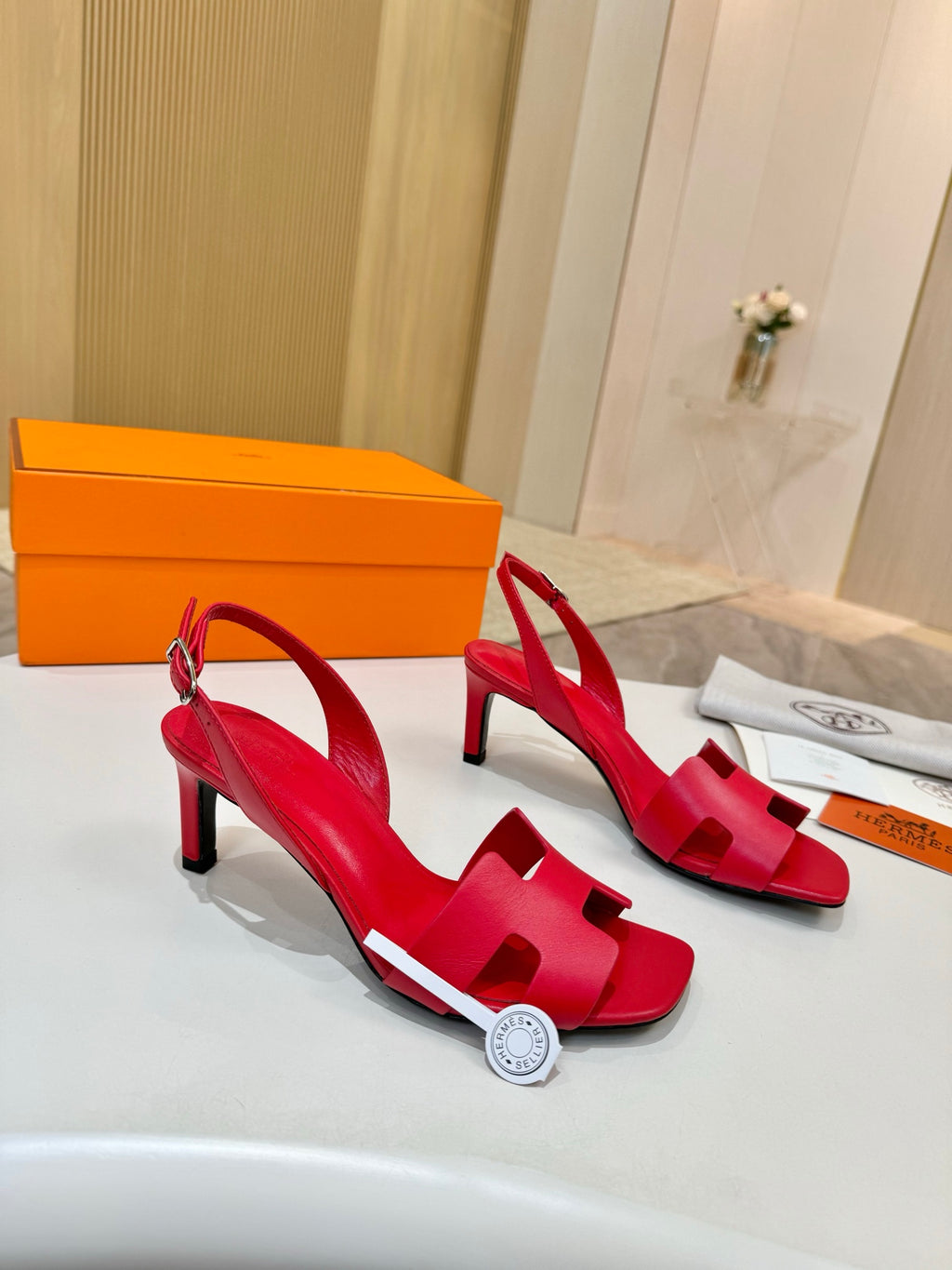 Hermes ladies red leather high-heel sandals displayed with orange gift box