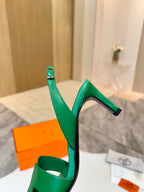 Green heeled sandal with thin ankle strap and square toe, mid-height block heel