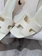 Close-up of white strappy heeled sandal upper with cutout panels