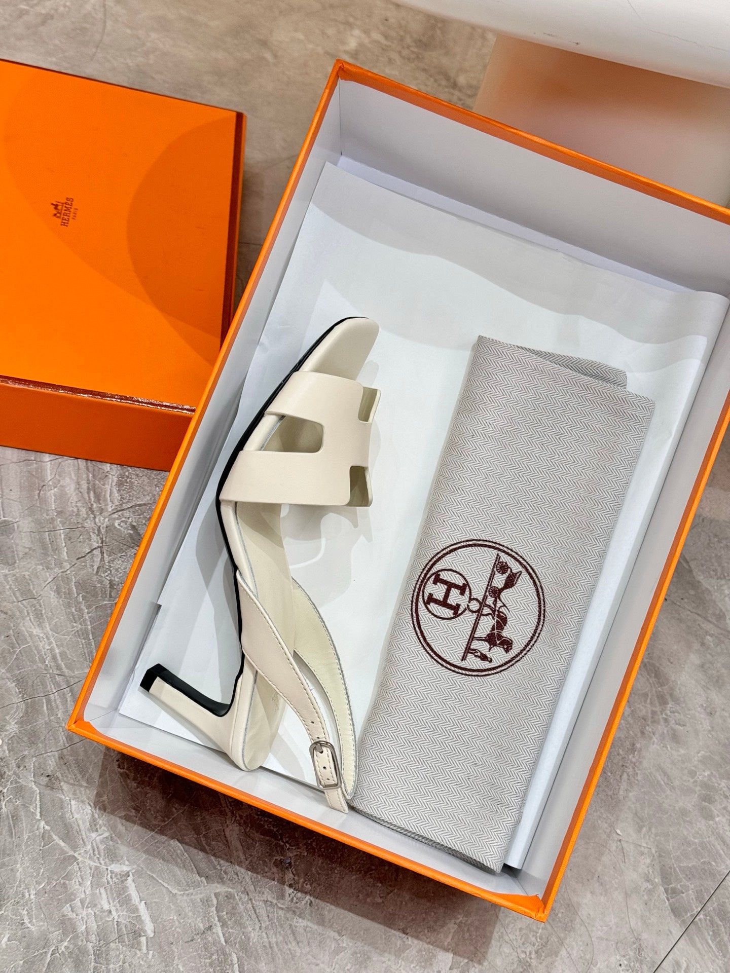 White heeled sandals in open box with matching dust bag