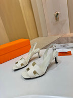 White strappy heeled sandals with open toe and ankle buckle, side view