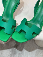 Close-up of green open-toe heeled sandals showing front strap details