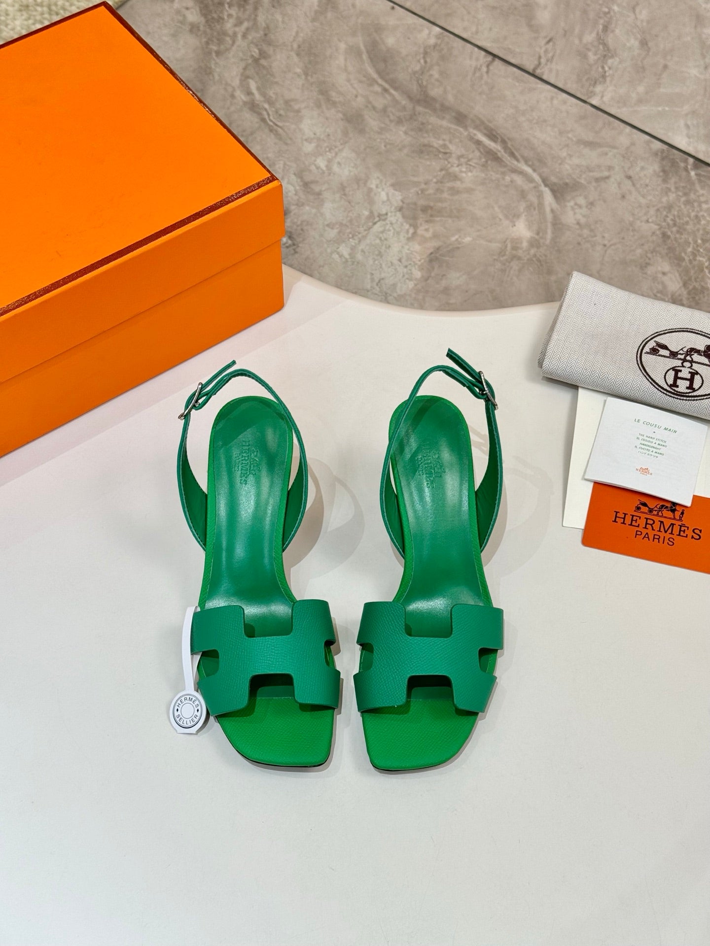 Green open-toe heeled sandals with ankle straps, laid on a white surface