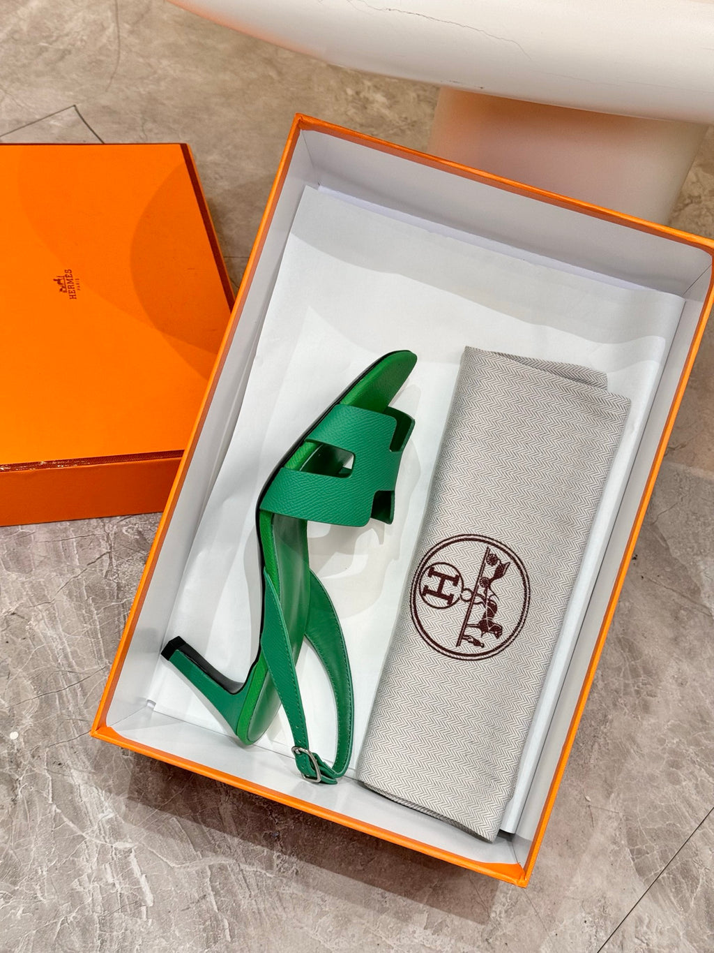 Green open-toe heeled sandals in an orange gift box with ankle strap