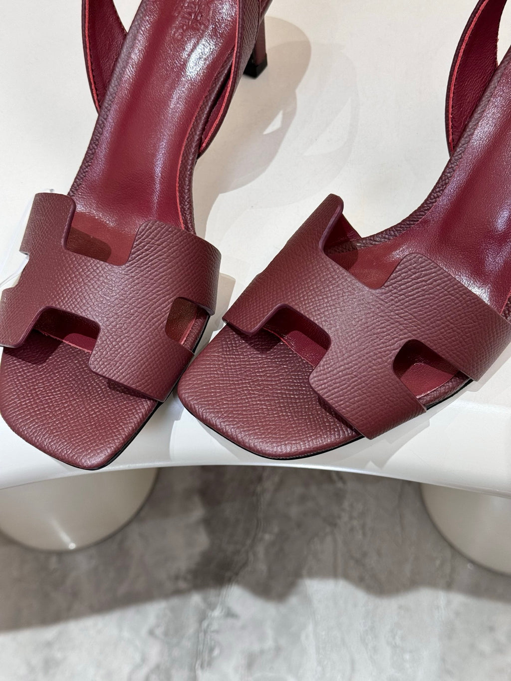 Burgundy leather heeled sandals close-up of textured straps and T-strap buckle area.