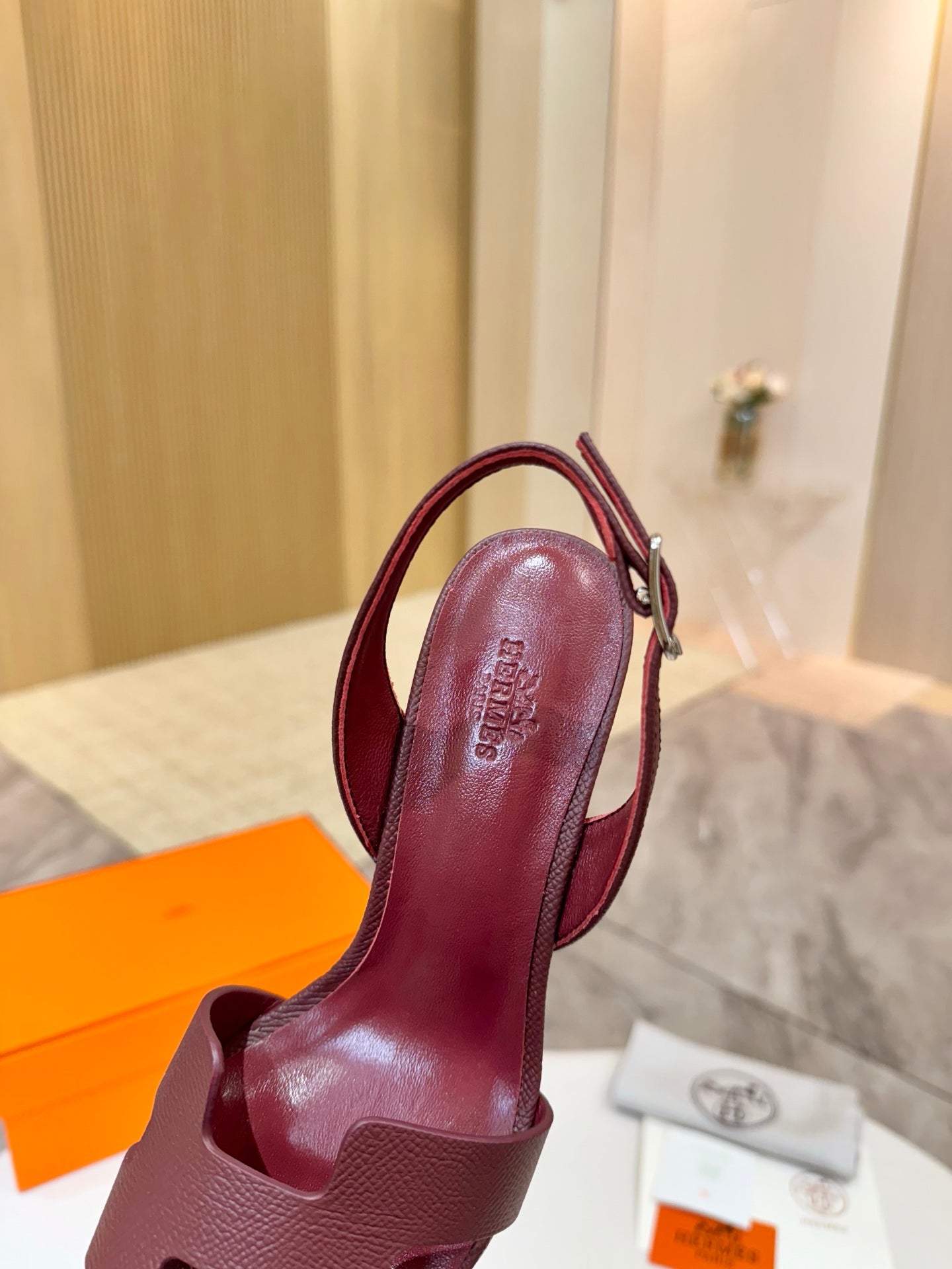 Burgundy leather slingback heeled sandal with textured ankle strap and open toe.