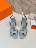 Pair of light blue slingback heeled sandals with T-shaped cutout straps