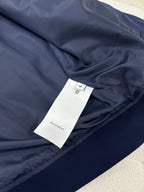 Dark blue bomber jacket with size label and ribbed hem detail