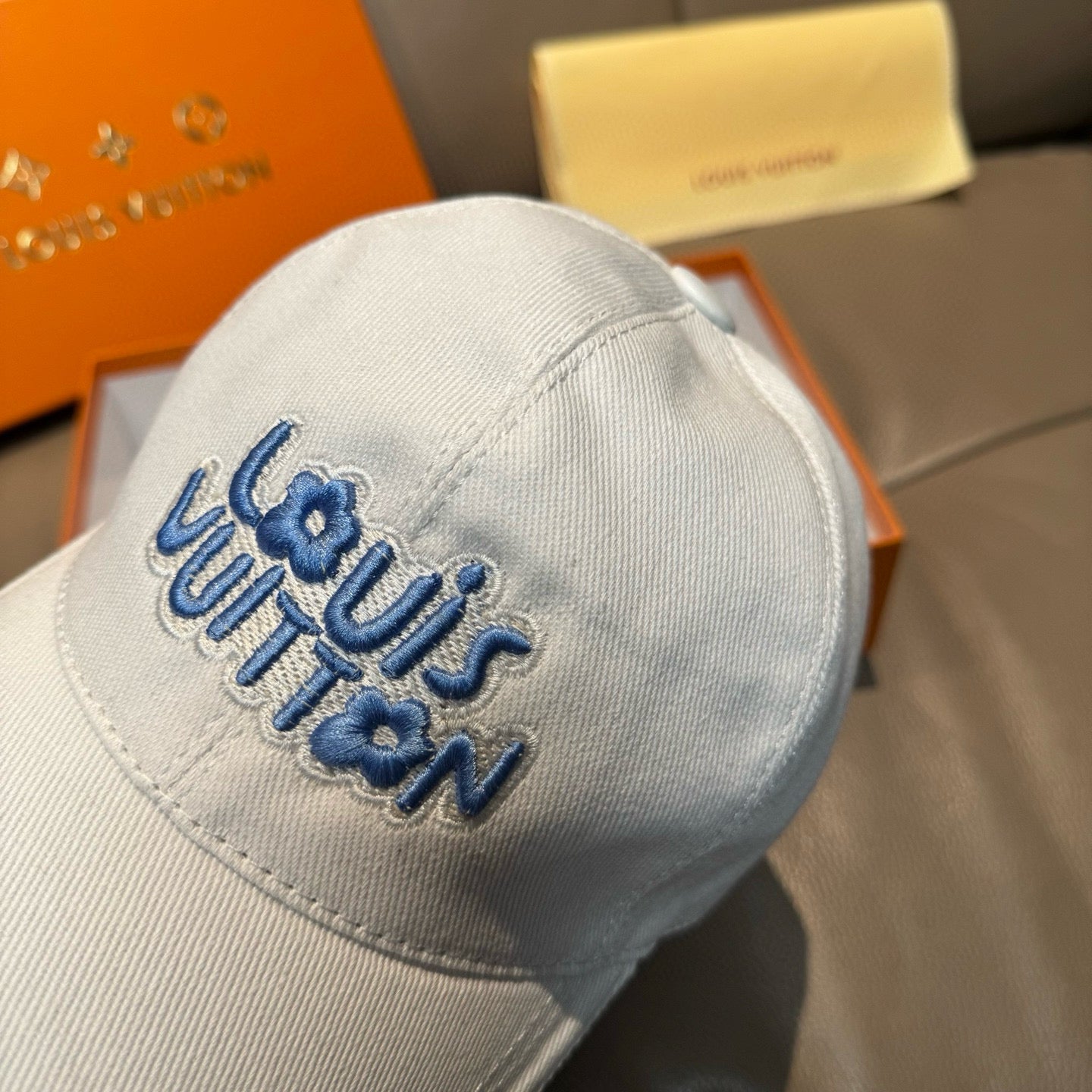 Louis Vuitton white cap with large blue logo lettering on front panel
