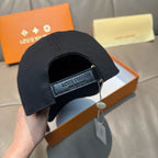 Black Louis Vuitton baseball cap with adjustable strap and hanging charm