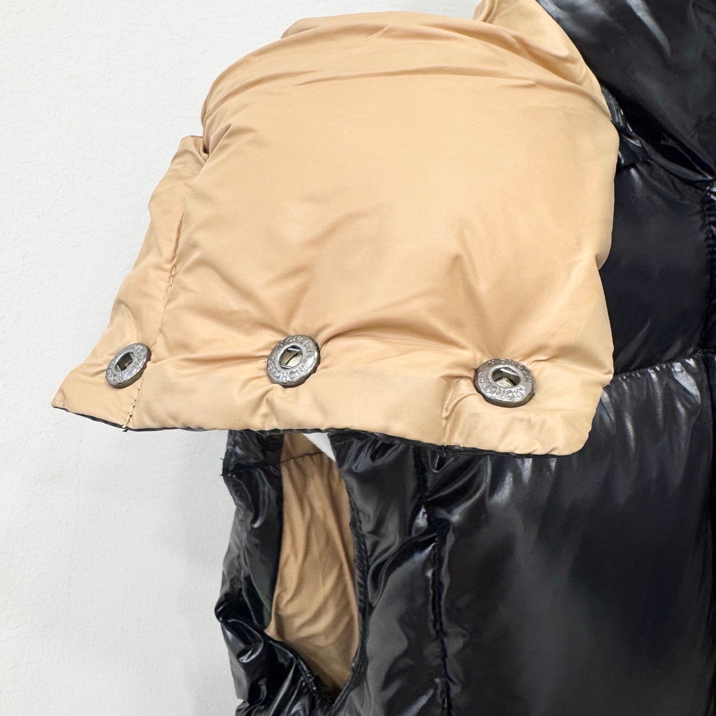Moncler long puffer jacket with beige hood lining and dark quilted body, side view