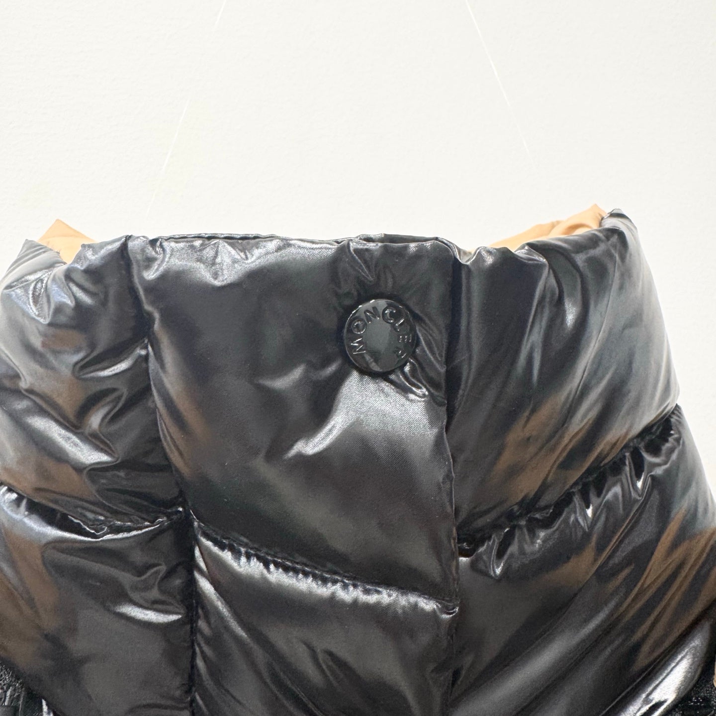 Moncler long puffer jacket chest logo patch on shiny dark quilted fabric