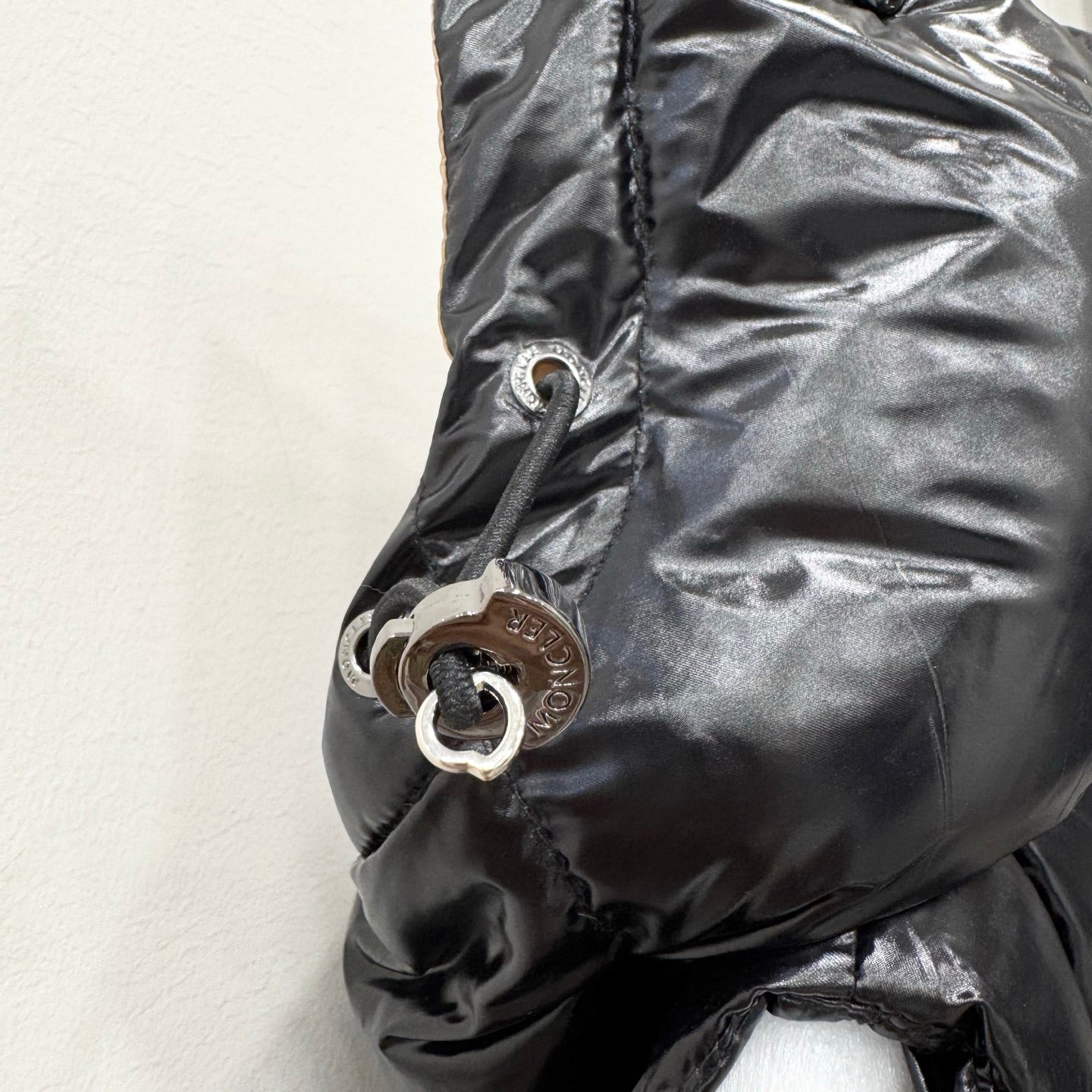 Moncler long puffer jacket hood pull and logo patch on dark fabric
