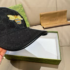 Black Gucci baseball cap close-up of bee patch on dark monogram fabric