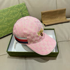 Pink baseball cap with monogram print, bee badge, and striped trim on side
