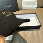 Prada baseball cap, black side view with logo on front panel and brim.