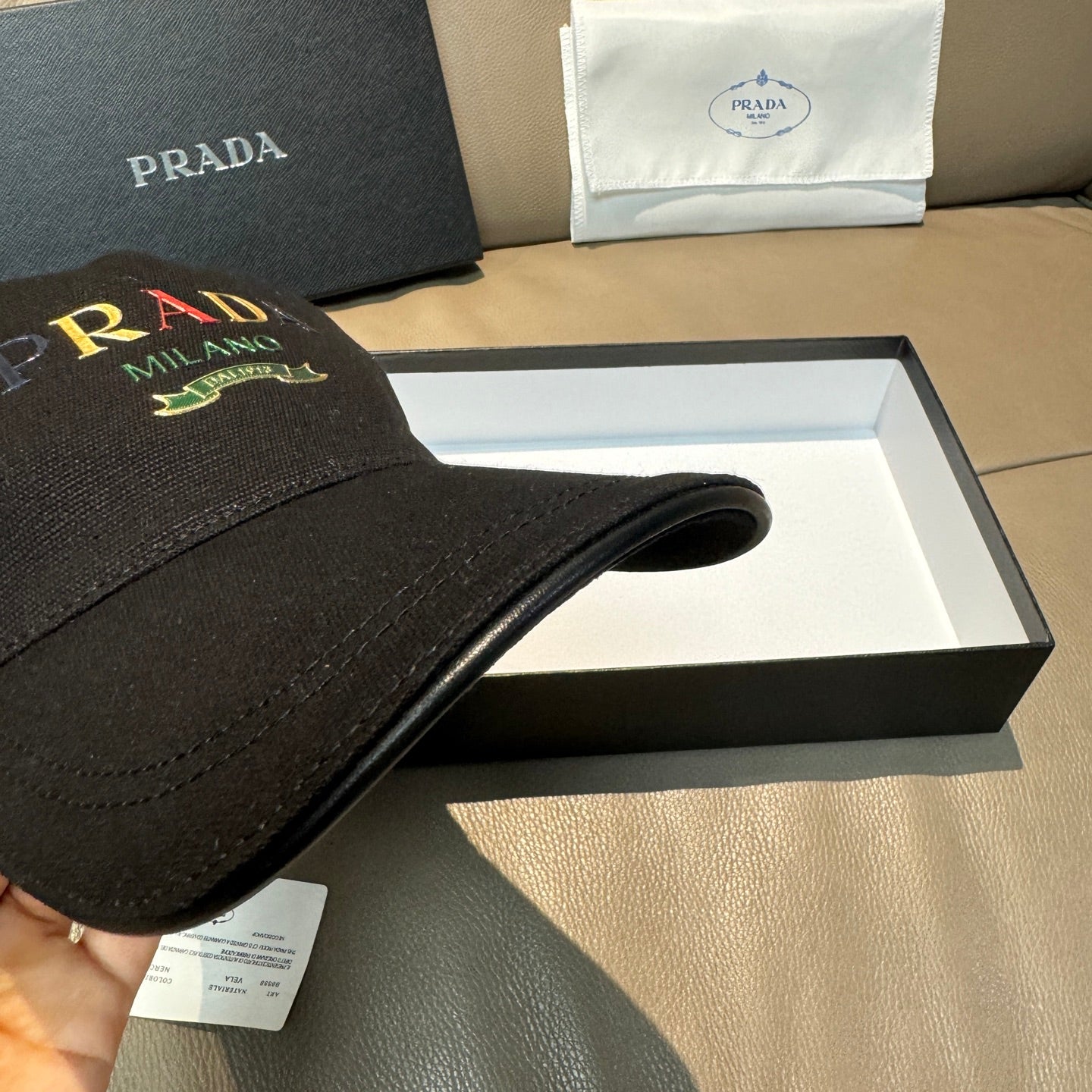 Prada baseball cap, black side view with logo on front panel and brim.