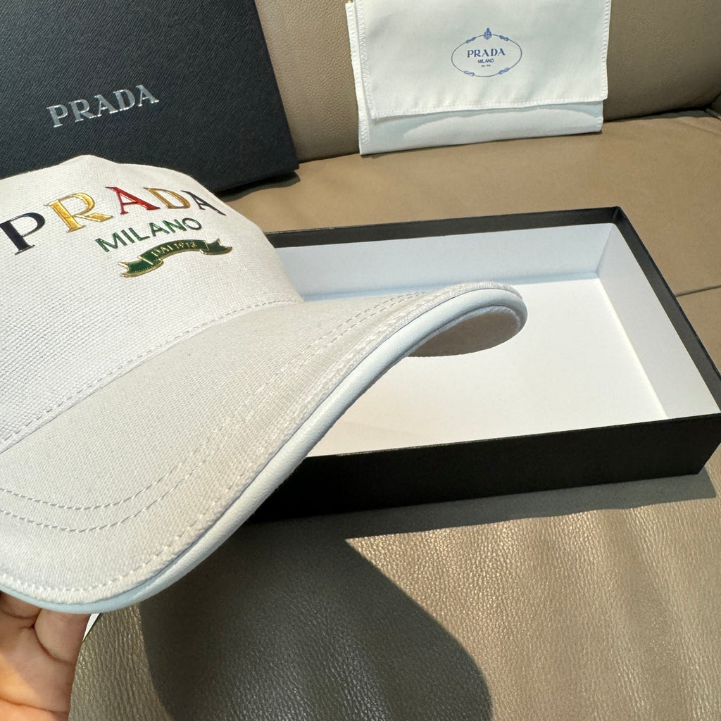 White Prada cap side profile with front PRADA MILANO logo and curved brim.