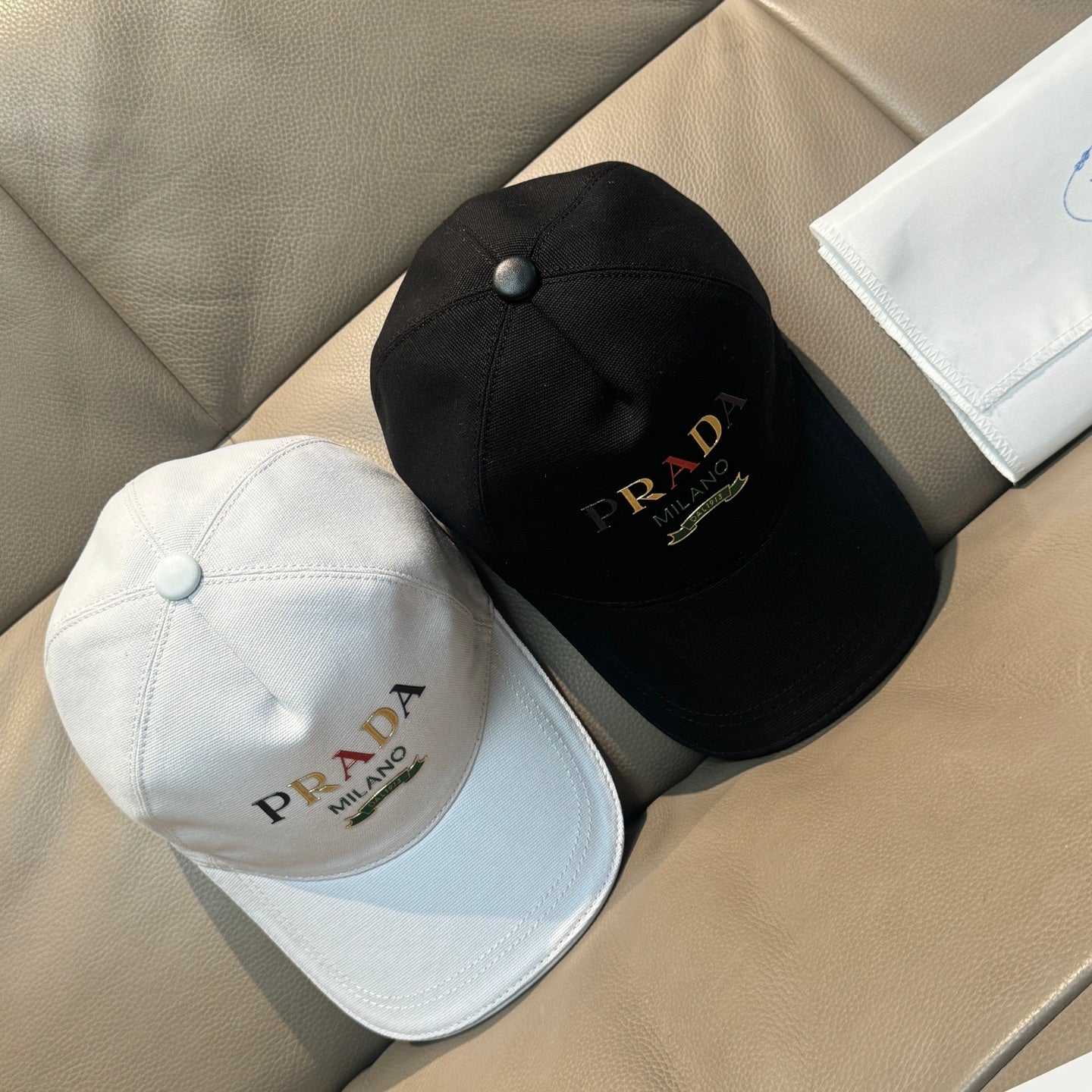 Prada baseball caps, black and white with front logo embroidery.