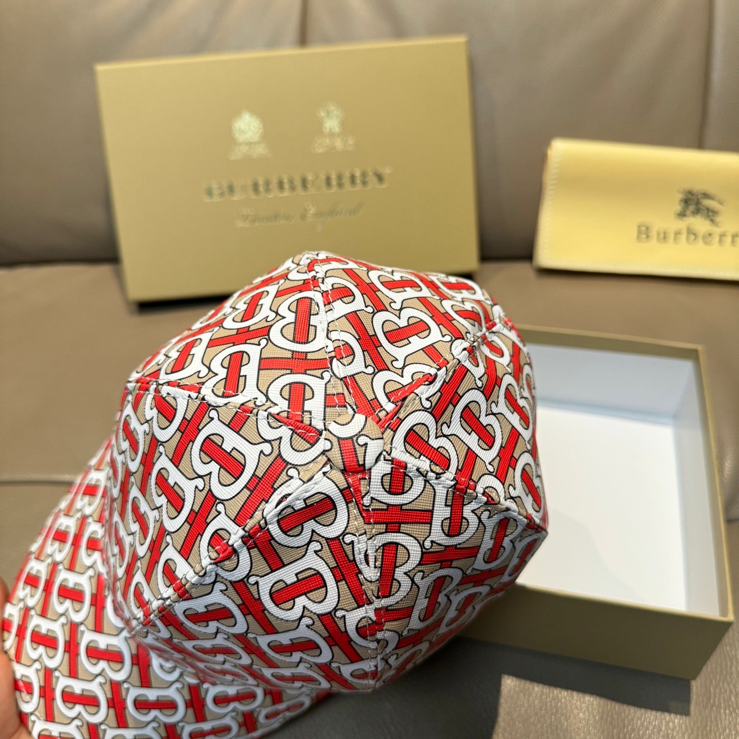 Baseball cap with red and white TB monogram pattern, close-up side detail.