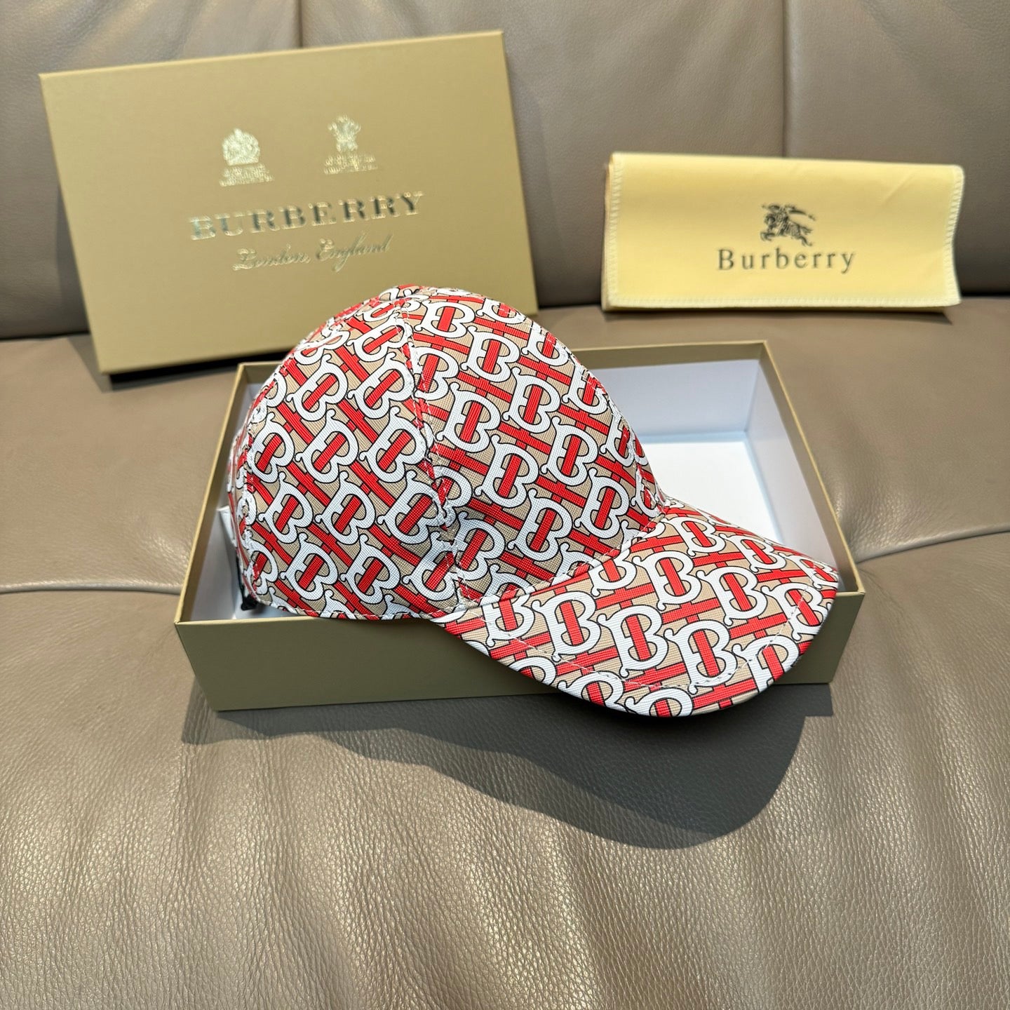 Baseball cap with red and white TB monogram pattern, angled front view.
