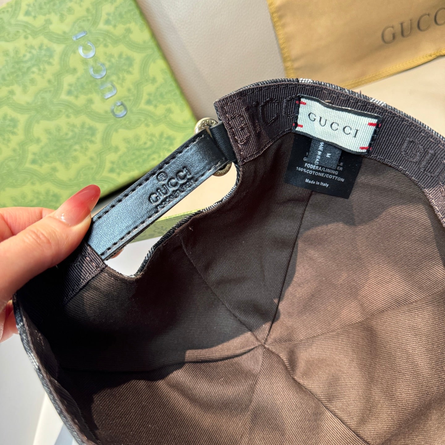 Baseball cap interior with adjustable strap and Gucci label near metal ring