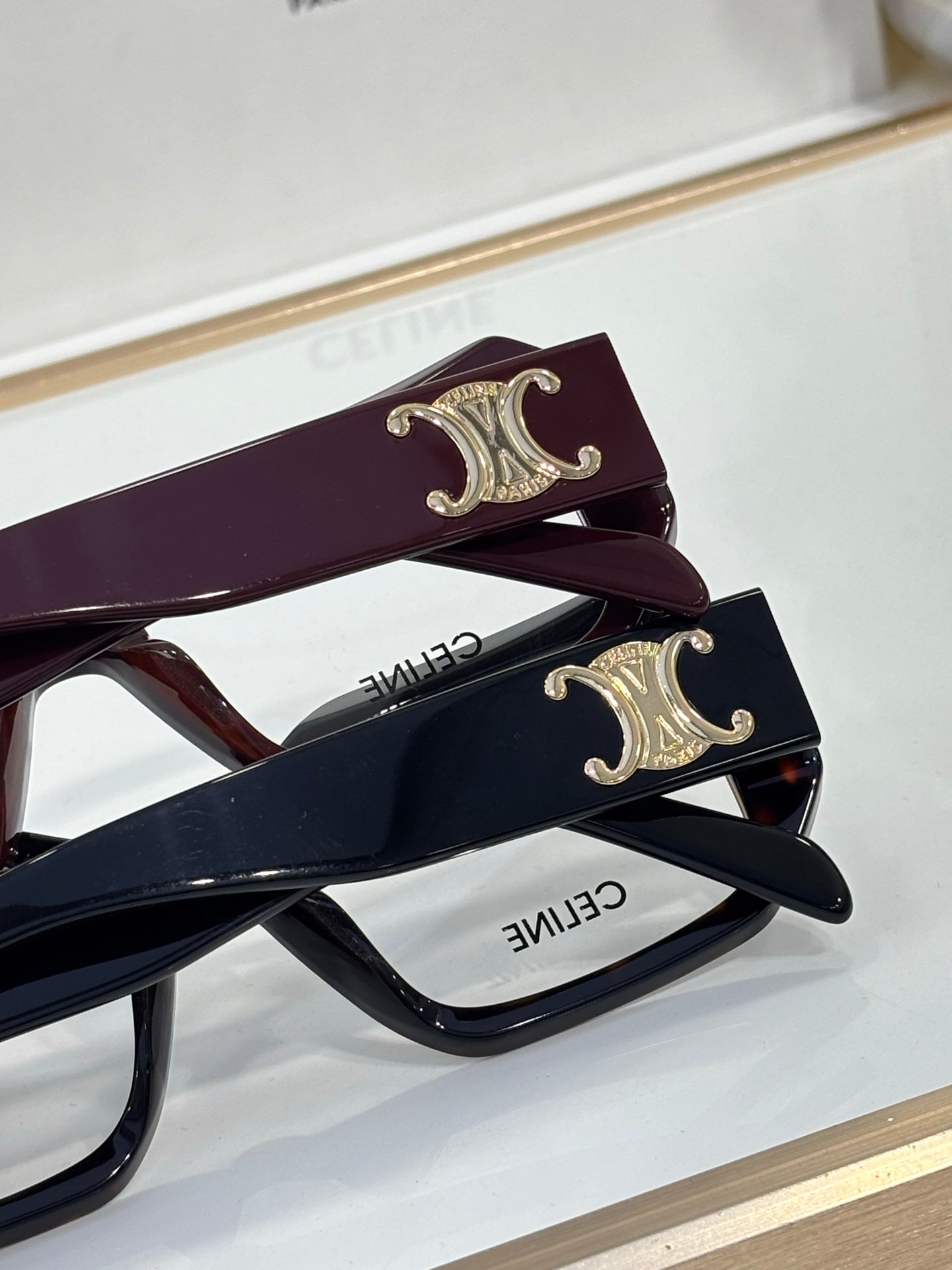 Celine glasses close-up, burgundy and navy temples with gold C emblems
