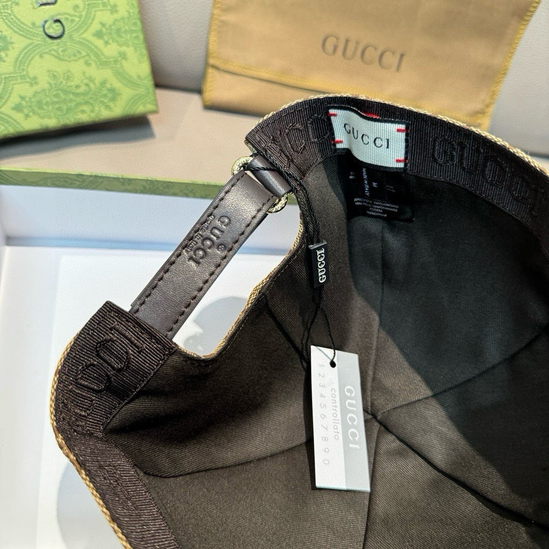 Black baseball cap with Gucci web stripe and hanging tags on the brim and strap.