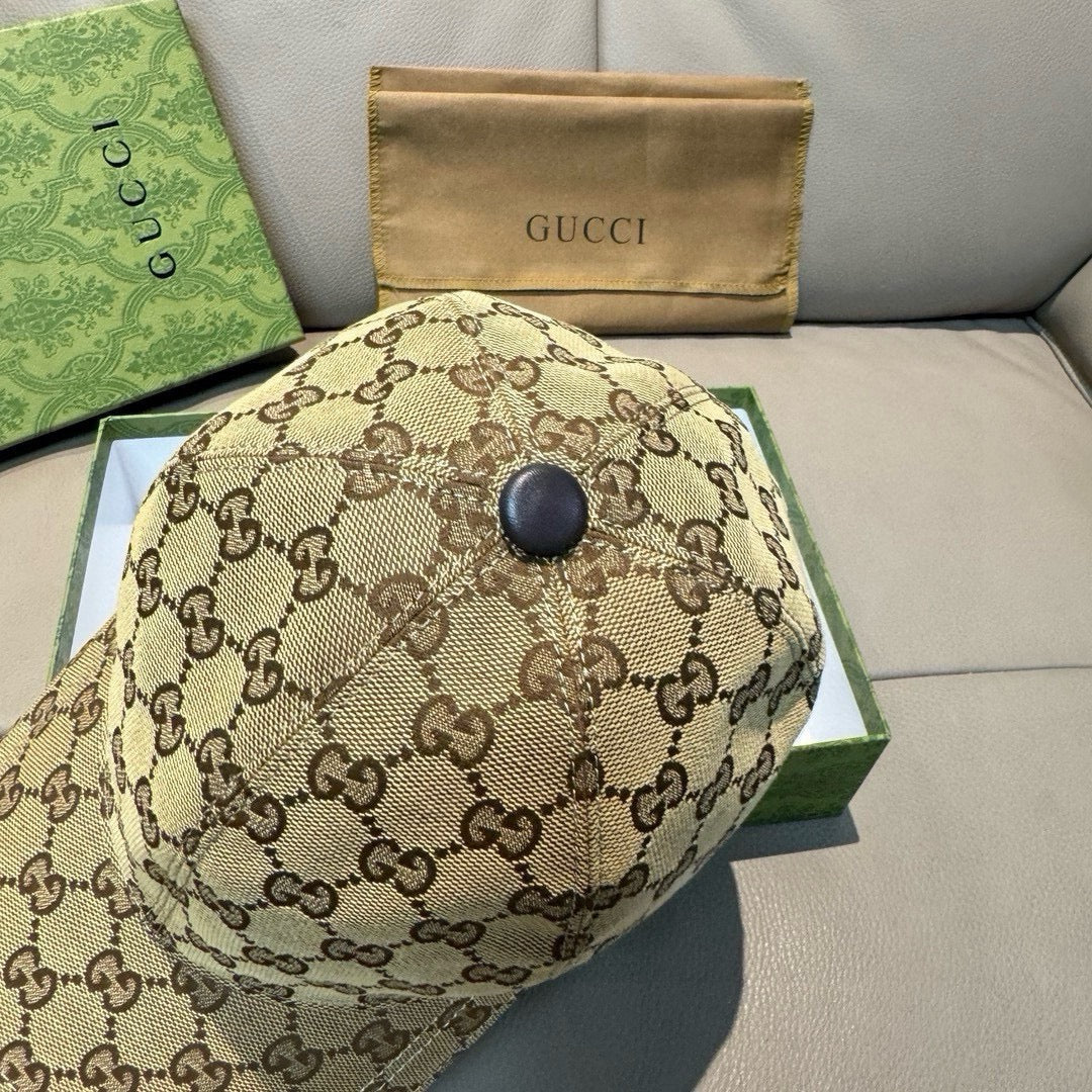 Tan GG canvas baseball cap with round top button and GG pattern throughout.