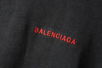 Balenciaga hoodie fabric close-up in dark gray with small red BALENCIAGA mark