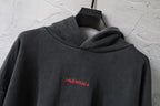 Balenciaga hoodie close-up in dark gray with hood and small red BALENCIAGA logo