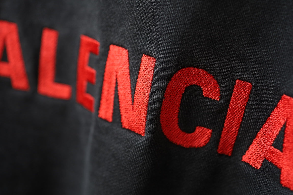 Balenciaga hoodie fabric close-up in dark gray with red BALENCIAGA lettering