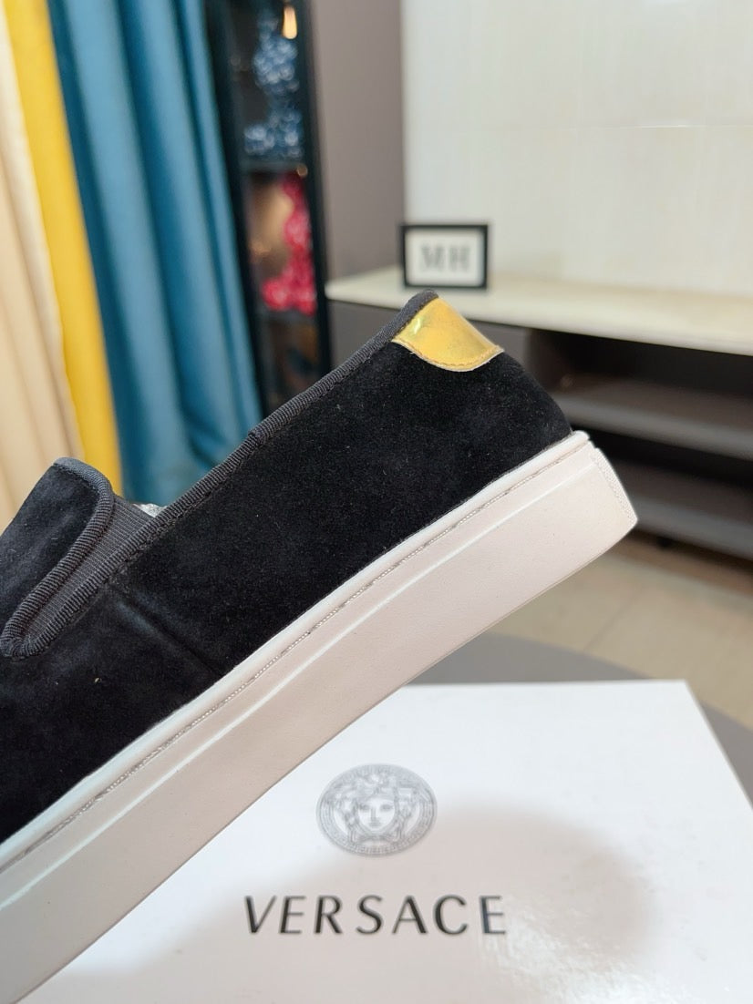 Black suede slip-on sneakers, side profile showing white rubber sole and yellow top
