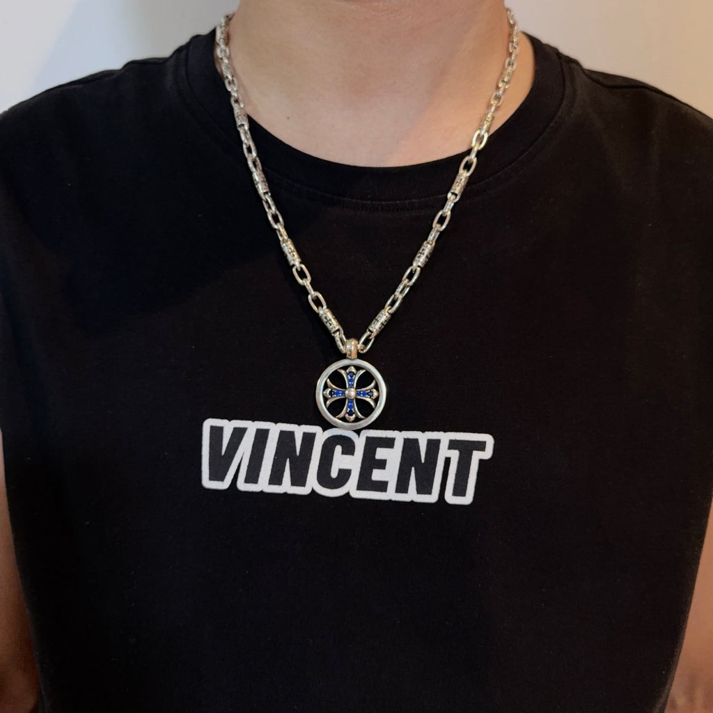 Chrome pendant necklace with round medallion and blue cross on a silver chain